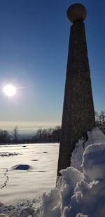 Scenic view of snow covered field against sky