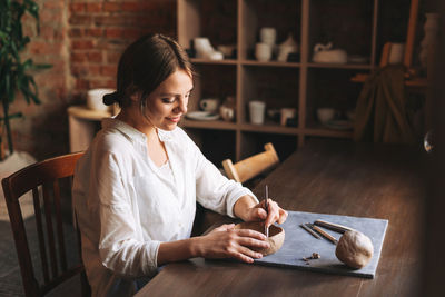 Young woman sitting on table at cafe