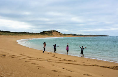 People on beach against sky