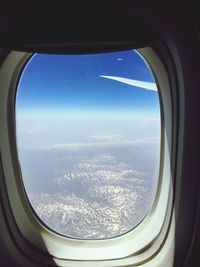 Aerial view of airplane wing seen through window