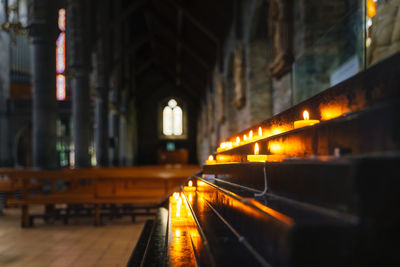 Lit candles with blurred background of interior of st. marys cathedral in killarney, ireland