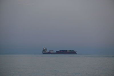 Ship sailing in sea against sky