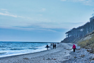 People on beach against sky