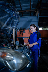 Rear view of young woman standing in factory