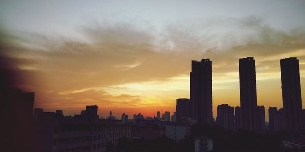 Silhouette buildings against sky during sunset