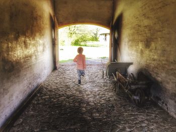 Rear view of boy walking in corridor