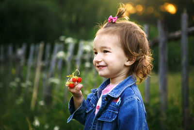 Portrait of woman holding flower against blurred background