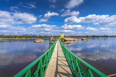 A bridge leading to the buddha's footprint in the middle of the mekong river in tha uthen district
