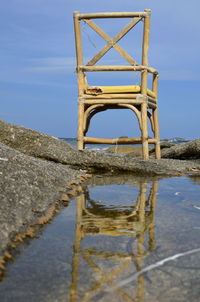 Scenic view of sea against sky with old chair