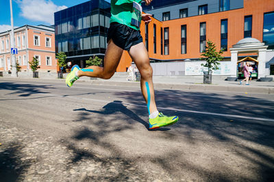 Low section of woman jumping on road