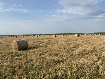 Hay bales on field against sky