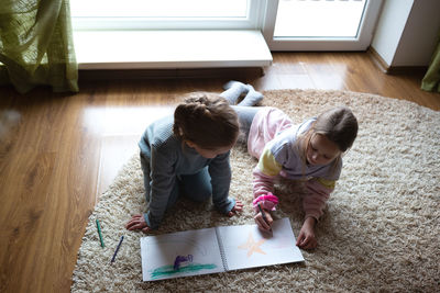 High angle view of boy playing with teddy bear