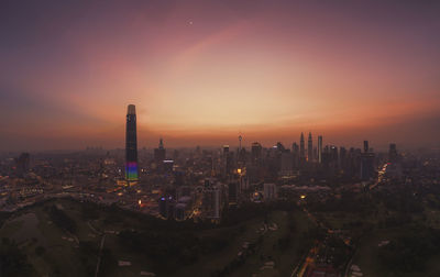 Aerial view of modern buildings in city against sky during sunset