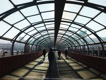 Rear view of woman walking under bridge