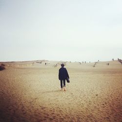 Rear view of man walking on desert