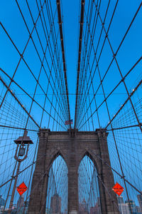 Low angle view of brooklyn bridge against blue sky