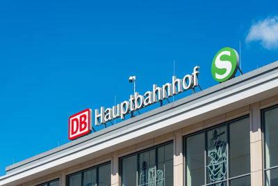 Low angle view of information sign against blue sky