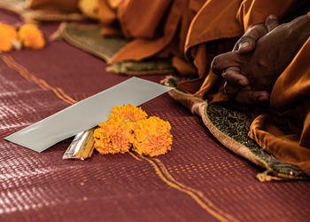 Low section of monk with flowers and incense