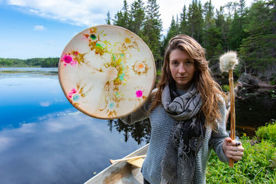 Portrait of smiling woman standing against sky