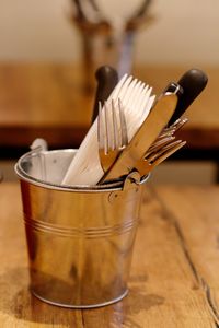 Close-up of cutlery in container on table