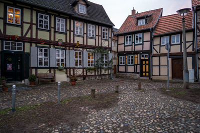 Houses by street in city against sky