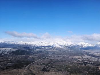 Scenic view of snowcapped mountains against blue sky