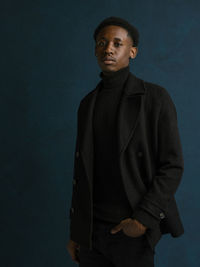 Young man standing against gray background