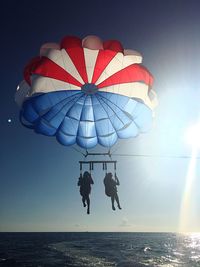 People in sea against sky