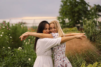 Smiling mother and daughter embracing in garden
