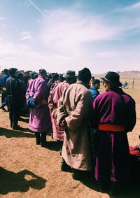 Rear view of people walking against sky