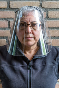 Portrait of woman with a face shield, wearing glasses to prevent the spread of covid-19