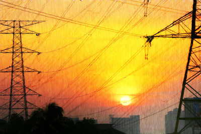 Silhouette of electricity pylon at sunset