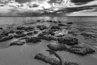 Scenic view of rocks on beach against sky