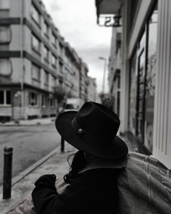 Rear view of man wearing hat standing in city