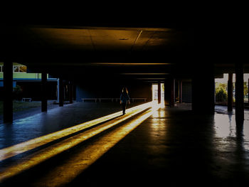 A young girl walks into the light at school into the sun