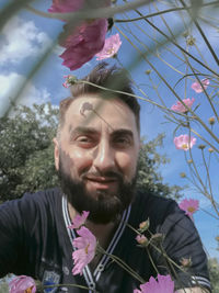 Portrait of young man with red flowers