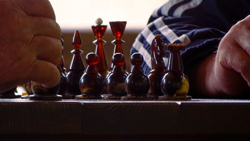 Close-up of people holding chess pieces