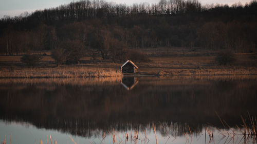 Scenic view of lake by trees against sky