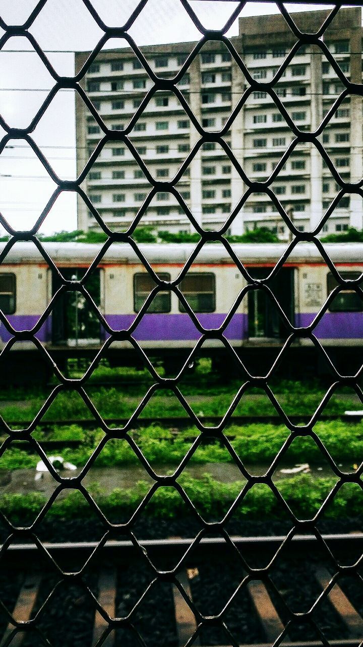 FULL FRAME SHOT OF CHAINLINK FENCE BY BUILDING