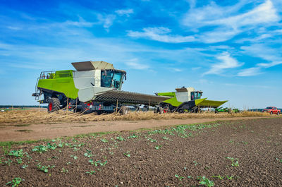 Autumn field with harvester on sky background. agricultural harvester collects harvest in field