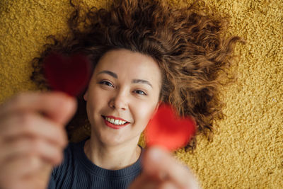 Closeup portrait of a smiling woman holding two hearts