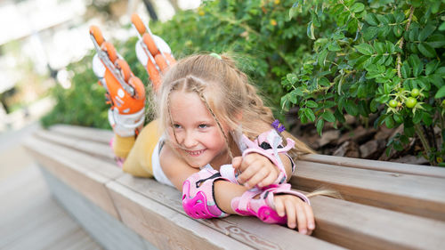 Smiling girl lying on bench outdoors