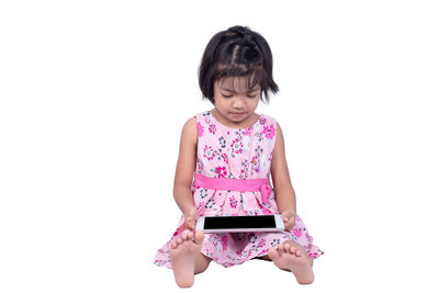 Full length of a girl holding mobile phone against white background