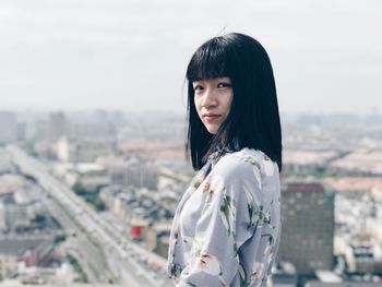 Beautiful young woman standing against sky