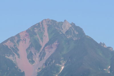 Low angle view of mountains against clear blue sky