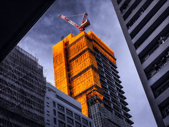 Low angle view of construction buildings against sky in city