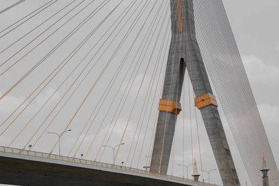 Low angle view of suspension bridge against sky