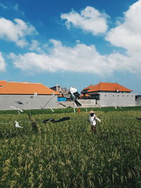 Built structure by field against sky