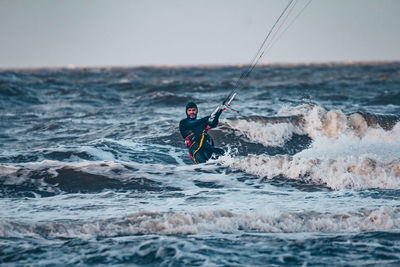 Man surfing on sea against sky