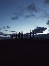 Silhouette people on beach against sky